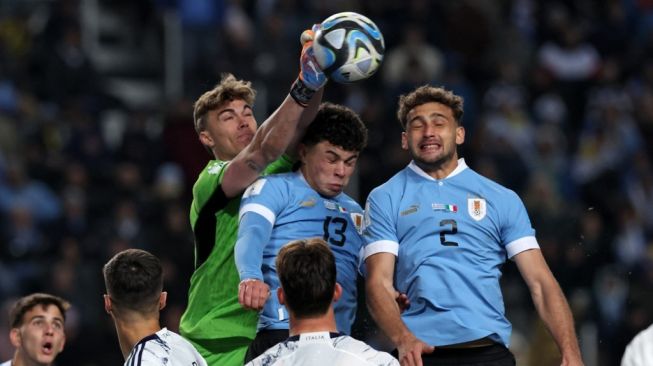 Kiper timnas Italia U-20 Sebastiano Desplanches (kiri) berebut bola dengan bek Uruguay U-20 Alan Matturro (tengah) dan bek Uruguay U-20 Sebastian Boselli (kanan) saat pertandingan final Piala Dunia U-20 2023 Argentina antara Uruguay vs Italia di stadion Estadio Unico Diego Armando Maradona di La Plata, Argentina, pada 11 Juni 2023.Alejandro PAGNI/AFP.