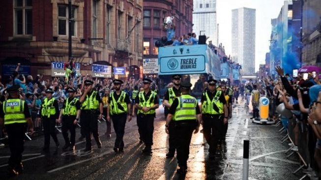 Gelandang Manchester City asal Spanyol Rodri memegang Piala Liga Champions saat ia merayakan bersama rekan setimnya tiga trofi mereka termasuk Piala FA dan Liga Premier selama parade kemenangan bus atap terbuka di jalan-jalan Manchester, Inggris utara pada 12 Juni 2023. Paul ELLIS / AFP