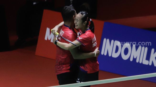 Pebulu tangkis ganda campuran Indonesia Lisa Ayu Kusumawati dan Rehan Naufal Kusharjanto berpelukan  usai mengalahkan ganda campuran Malaysia Goh Soon Huat dan Shevon Jemie Lai dalam babak pertama (32 besar) turnamen Indonesia Open 2023 di Istora Senayan, Jakarta, Selasa (13/6/2023). [Suara.com/Alfian Winanto]