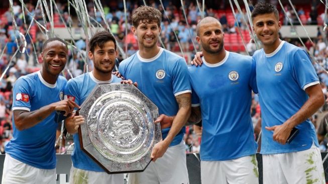 (Kiri-Kanan) Gelandang Manchester City Raheem Sterling, David Silva, bek John Stones, bek Kyle Walker dan gelandang Rodrigo berpose dengan trofi setelah memenangkan pertandingan sepak bola Community Shield FA Inggris antara Manchester City dan Liverpool di Stadion Wembley di London utara pada 4 Agustus 2019.Adrian DENNIS / AFP.