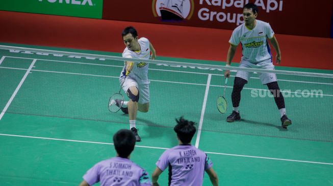 Pebulu tangkis ganda putra Indonesia Mohammad Ahsan (atas kiri) dan Hendra Setiawan (atas kanan) saat bertanding dengan ganda putra Thailand Supak Jomkoh dan Kittinupong Kedren dalam babak pertama (32 besar) turnamen Indonesia Open 2023 di Istora Senayan, Jakarta, Rabu (14/6/2023). [Suara.com/Alfian Winanto]
