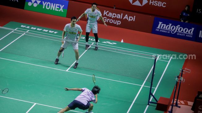 Pebulu tangkis ganda putra Indonesia Mohammad Ahsan (atas kiri) dan Hendra Setiawan (atas kanan) saat bertanding dengan ganda putra Thailand Supak Jomkoh dan Kittinupong Kedren dalam babak pertama (32 besar) turnamen Indonesia Open 2023 di Istora Senayan, Jakarta, Rabu (14/6/2023). [Suara.com/Alfian Winanto]
