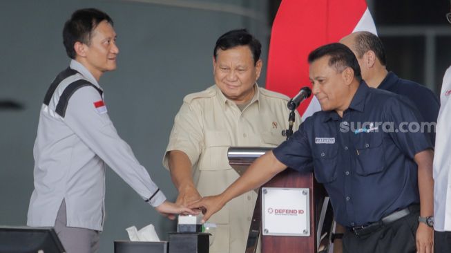 Menteri Pertahanan, Prabowo Subianto (tengah) Bersama Direktur Utama holding BUMN industri pertahanan DEFEND ID dan PT Len Industri, Bobby Rasyidin (kiri) dan Direktur Utama PT Pindad, Abraham Mose (kanan) saat meresmikan acara “The 1st DEFEND ID’s Day” di Hanggar PT Dirgantara Indonesia, Bandung, Jawa Barat, Kamis (15/6/2023). [Suara.com/Alfian Winanto]