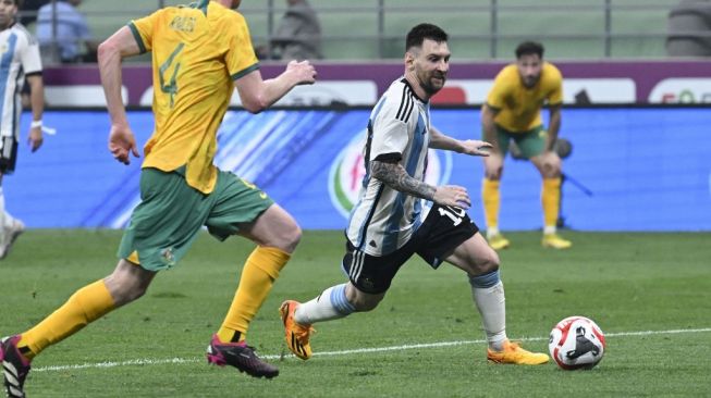 Pemain Argentina Lionel Messi (tengah) berebut bola dengan pemain Australia Aziz Behich (kiri) dalam pertandingan persahabatan FIFA Matchday antara Argentina vs Australia di Stadion Pekerja di Beijing pada 15 Juni 2023. WANG Zhao / AFP.