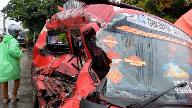 Warga mengamati angkot yang ringsek setelah tertabrak KRL KA 1187 (Bogor-Jakarta Kota) di perlintasan sebidang Rawa Indah antara Stasiun Citayam-Depok, Jawa Barat, Jumat (16/6/2023). [ANTARA FOTO/Andika Wahyu].