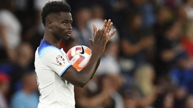 Gelandang Inggris Bukayo Saka memberikan aplaus pada suporternya setelah mencetak hat-trick pada pertandingan kualifikasi grup C UEFA Euro 2024 menghadapi Makedonia Utara di Old Trafford di Manchester, Inggris, pada 19 Juni 2023. Inggris memenangkan pertandingan 7-0.Oli SCARFF/AFP