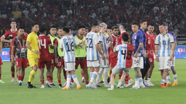 Seorang suporter mengenakan jersey Timnas Indonesia dan Argentina masuk ke dalam lapangan Stadion Utama Gelora Bung Karno (SUGBK), Senayan, Jakarta, Senin (19/6/2023). [Suara.com/Dwi Bowo Raharjo]