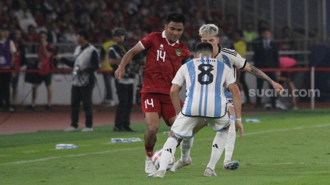 Pemain Timnas Indonesia Asnawi Mangkualam mencoba melwtati pemain Argentina pada laga FIFA Matchday di Stadion Utama Gelora Bung Karno, Senayan, Jakarta, Senin (19/6/2023) malam. [Suara.com/Dwi Bowo Raharjo]