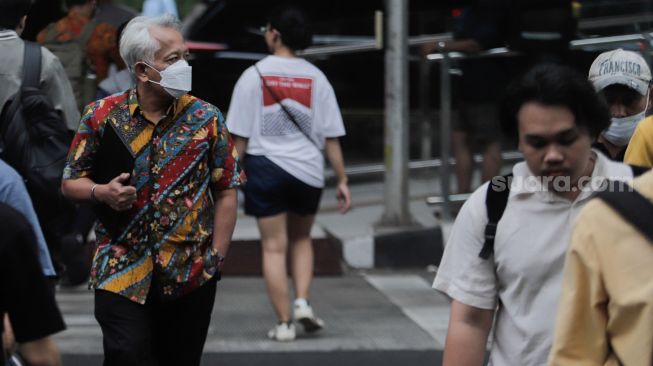 Pejalan kaki memakai masker saat melintas di Kawasan Bundaran HI, Jakarta, Rabu (21/6/2023). [Suara.com/Alfian Winanto]