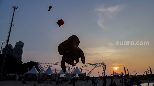 Peserta menerbangkan layang-layang saat Festival Layang-layang Jakarta di Pantai Lagoon Ancol, Kamis (22/6/2023). [Suara.com/Alfian Winanto]