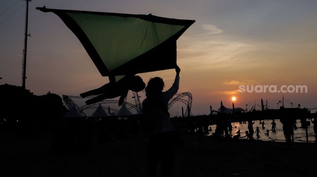 Peserta menerbangkan layang-layang saat Festival Layang-layang Jakarta di Pantai Lagoon Ancol, Kamis (22/6/2023). [Suara.com/Alfian Winanto]