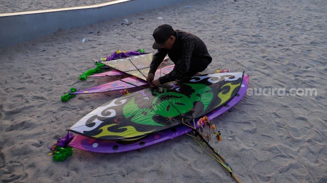 Peserta menyiapkan layang-layang saat Festival Layang-layang Jakarta di Pantai Lagoon Ancol, Kamis (22/6/2023). [Suara.com/Alfian Winanto]