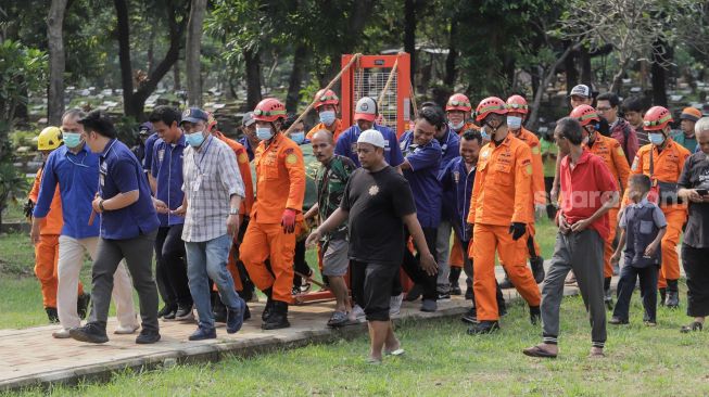 Tim gabungan dari Basarnas dan Damkar membawa jenazah Fajri, pria obesitas 300 kg, menggunakan forklit untuk dimakamkan di Taman Pemakaman Umum (TPU) Menteng Pulo, Jakarta, Kamis (22/6/2023). [Suara.com/Alfian Winanto]