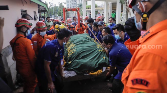 Tim gabungan dari Basarnas dan Damkar membawa jenazah Fajri, pria obesitas 300 kg, menggunakan forklit untuk dimakamkan di Taman Pemakaman Umum (TPU) Menteng Pulo, Jakarta, Kamis (22/6/2023). [Suara.com/Alfian Winanto]