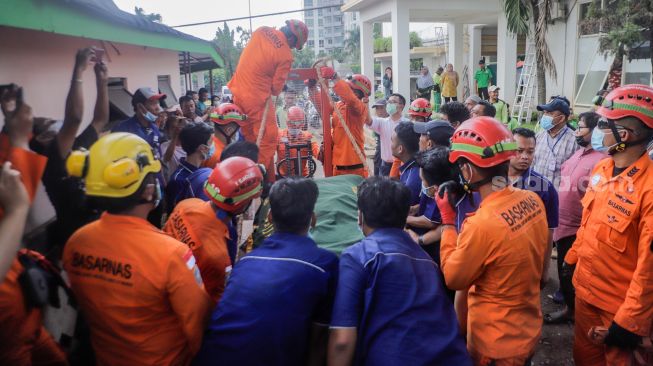 Tim gabungan dari Basarnas dan Damkar membawa jenazah Fajri, pria obesitas 300 kg, menggunakan forklit untuk dimakamkan di Taman Pemakaman Umum (TPU) Menteng Pulo, Jakarta, Kamis (22/6/2023). [Suara.com/Alfian Winanto]