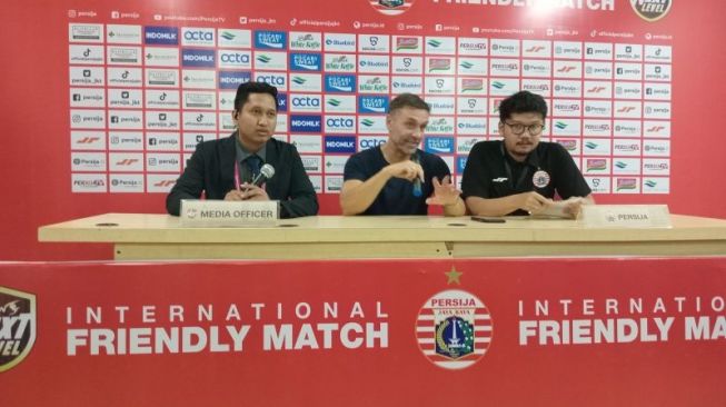 Pelatih Persija Jakarta Thomas Doll (tengah) menjawab pertanyaan pewarta pada konferensi pers setelah pertandingan persahabatan melawan Ratchaburi di Stadion Patriot Candrabagha, Bekasi, Minggu (25/6/2023). (ANTARA/RAUF ADIPATI)