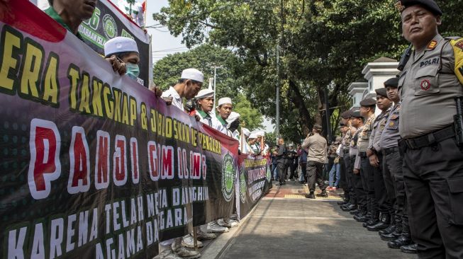 Petugas kepolisian melakukan pengamanan saat massa aksi yang tergabung dalam Front Persaudaraan Islam (FPI) melakukan aksi unjuk rasa di halaman kantor Kementerian Agama, Jakarta, Senin (26/6/2023). [ANTARA FOTO/Muhammad Adimaja].