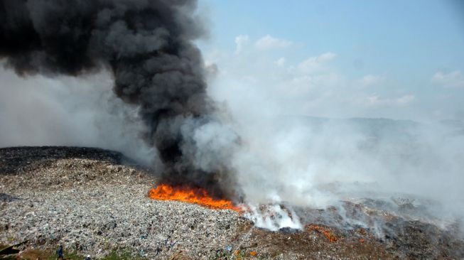 Petugas berusaha memadamkan api saat kebakaran lahan di Tempat Pembuangan Akhir (TPA) Desa Dermasuci, Kabupaten Tegal, Jawa Tengah, Selasa (27/6/2023). [ANTARA FOTO/Oky Lukmansyah].