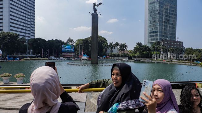 Warga saat menaiki Bus Wisata Transjakarta dengan atap terbuka di Jakarta, Rabu (28/6/2023). [Suara.com/Alfian Winanto]
