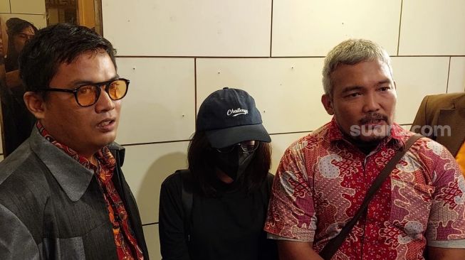 Eks Karyawan Tasyi Athasyia, Putri (mengenakan topi dan masker hitam) menjalani pemeriksaan di Polda Metro Jaya, terkait laporannya dalam tuduhan pengancaman dan kekerasa, Jumat (7/7/2023). [Rena Pangesti/Suara.com]