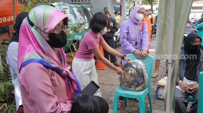 Petugas memasukan dosis vaksin rabies untuk disuntikan ke kucing di Kantor Kelurahan Manggarai Selatan, Jakarta Selatan, Senin (10/7/2023). [Suara.com/Alfian Winanto]