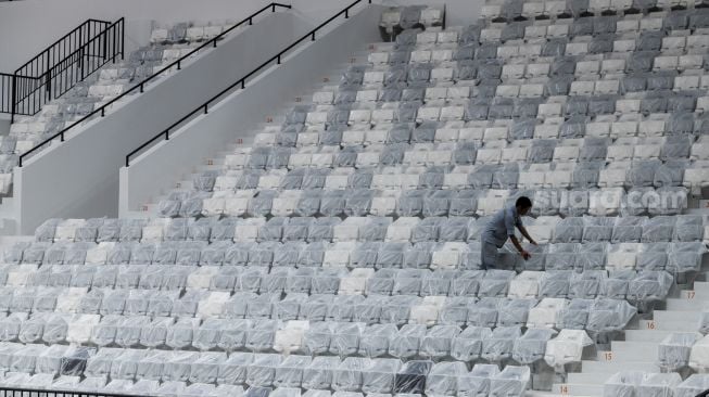 Petugas membersihkan tribun penonton di Indonesia Arena, Senayan, Jakarta, Selasa (11/7/2023). [Suara.com/Alfian Winanto]