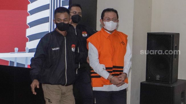 Tersangka sekretaris Mahkamah Agung (MA) Hasbi Hasan mengenakan pakaian tahanan saat dihadirkan dalam konferensi pers pengumuman penahanan tersangka di Gedung Merah Putih KPK, Jakarta, Rabu (12/7/2023). [Suara.com/Alfian Winanto]