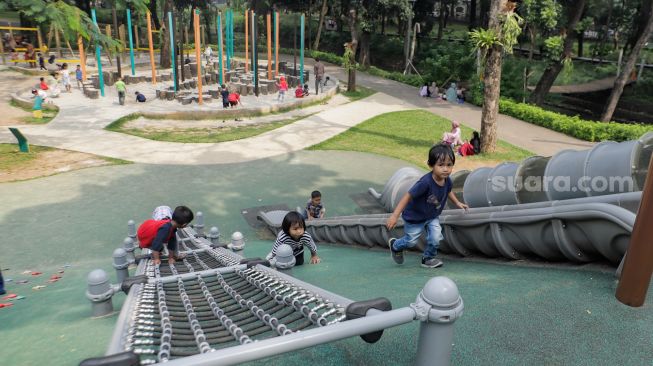 Anak-anak bermain saat berwisata di Tebet Eco Park, Jakarta Selatan, Kamis (13/7/2023). [Suara.com/Alfian Winanto]