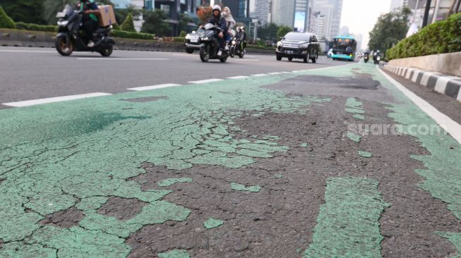 Sejumlah kendaraan melintas di kawasan Sudirman, Jakarta, Jumat (14/7/2023). [Suara.com/Alfian Winanto]