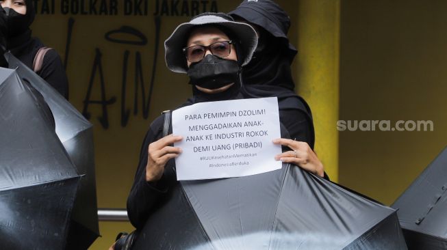 Sejumlah massa saat menggelar aksi unjuk rasa 'Payung Duka' di depan Kementerian Kesehatan, Jakarta, Jumat (14/7/2023). [Suara.com/Alfian Winanto]