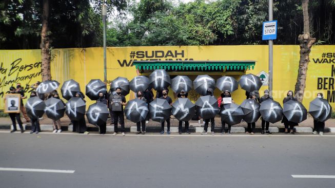 Sejumlah massa saat menggelar aksi unjuk rasa 'Payung Duka' di depan Kementerian Kesehatan, Jakarta, Jumat (14/7/2023). [Suara.com/Alfian Winanto]