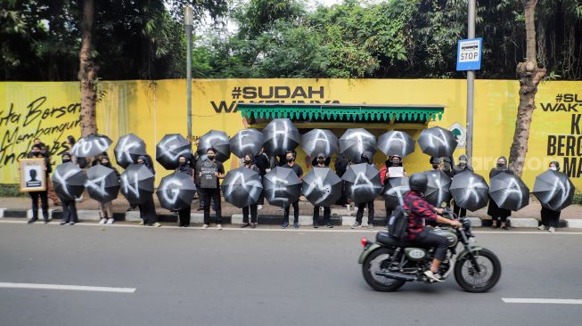 Sejumlah massa saat menggelar aksi unjuk rasa 'Payung Duka' di depan Kementerian Kesehatan, Jakarta, Jumat (14/7/2023). [Suara.com/Alfian Winanto]