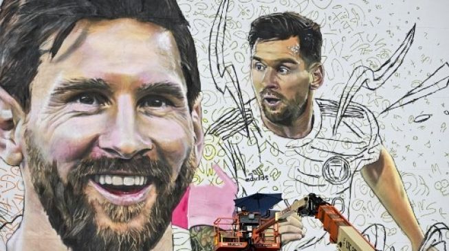 Artis Argentina Maximiliano Bagnasco melukis mural raksasa bintang sepak bola internasional Lionel Messi di Wynwood, distrik seni Miami, di Miami, Florida, pada 10 Juli 2023. CHANDAN KHANNA / AFP