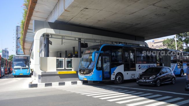 Bus Transjakarta melintas di Halte Transjakarta Kampung Melayu, Jakarta, Rabu (19/7/2023). [Suara.com/Alfian Winanto]