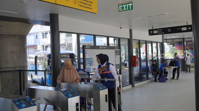 Calon penumpang menunggu kedatangan bus Transjakarta di Halte Transjakarta Kampung Melayu, Jakarta, Rabu (19/7/2023). [Suara.com/Alfian Winanto]