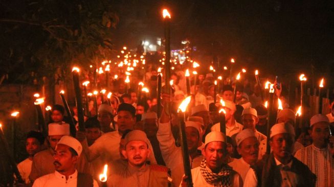 Ratusan santri Dayah Istiqamatuddin Nahdatul Huda (INAHU) bersama warga mengikuti pawai obor menyambut Tahun Baru Islam 1 Muharram 1445 Hijriah yang jatuh pada 19 Juli 2023 di Lhokseumawe, Aceh, Selasa (29/7/2022) malam. [ANTARA FOTO/Rahmad].