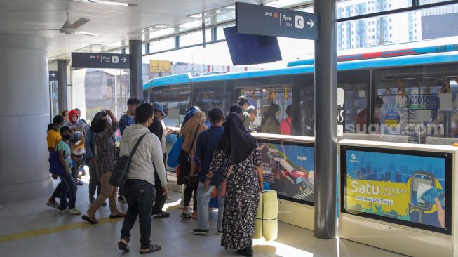 Calon penumpang menunggu kedatangan bus Transjakarta di Halte Transjakarta Kampung Melayu, Jakarta, Rabu (19/7/2023). [Suara.com/Alfian Winanto]