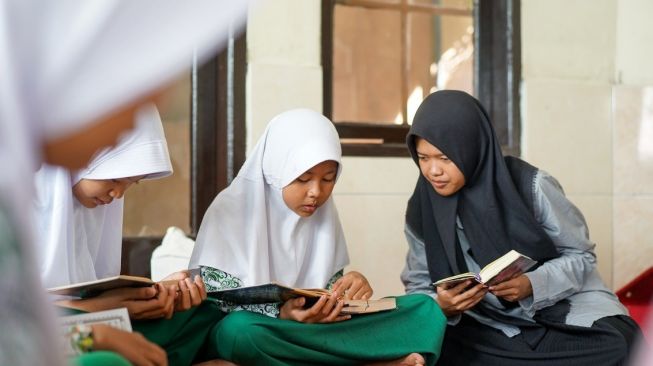 Momen Noni Cantika Wiguna, saat mengajar anak-anak dalam menghafal Al Quran di SD di Yayasan Daarul Haq Madani Indonesia, Bandung. (Dok.Istimewa)