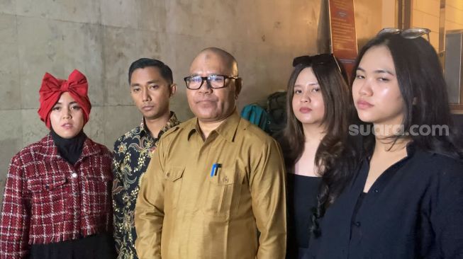 Pelapor Mario Teguh, Sunyoto Indra Prayitno (batik) bersama istri (kemeja merah), dua saksi dan pengacara Djamaluddin Koedoeboen di Polda Metro Jaya, Jakarta, Jumat dini hari (21/7/2023) [Suara.com/Adiyoga Priyambodo]