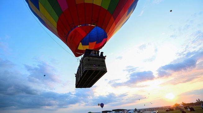 Sejumlah Balon udara lepas landas di pangkalan udara Chambley-Bussieres saat festival balon udara internasional ke-18 "Grand-Est Mondial Air Ballons" di Hageville, Prancis, Jumat (21/7/2023). [Jean-Christophe VERHAEGEN / AFP]