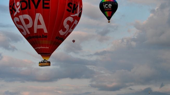 Sejumlah Balon udara terbang saat festival balon udara internasional ke-18 "Grand-Est Mondial Air Ballons" di Hageville, Prancis, Jumat (21/7/2023). [Jean-Christophe VERHAEGEN / AFP]
