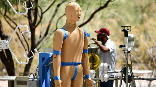 Para peneliti memantau penelitian tentang efek paparan gelombang panas pada tubuh manusia dengan Robot ANDI di Arizona State University (ASU), Phoenix, Arizona, Kamis (20/7/2023). [Patrick T. Fallon / AFP]