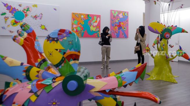 Pengunjung mengamati karya seni rupa karya Daniel Kho dalam pameran yang bertajuk Castaneda Factor di Galeri Jagad, Menteng, Jakarta, Minggu (23/7/2023). [Suara.com/Alfian Winanto]
