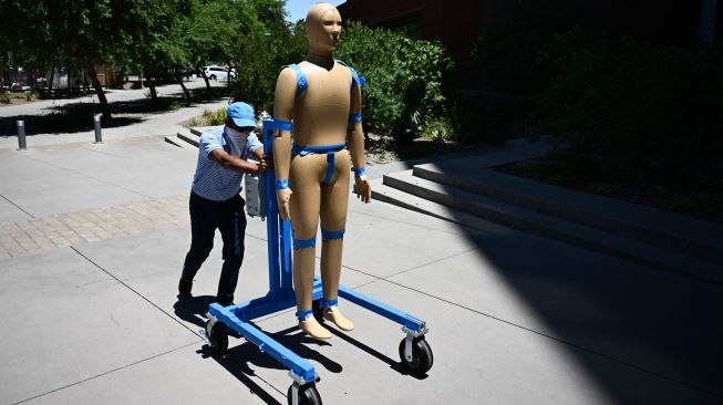 Peneliti membawa Robot ANDI dari laboratorium ke lapangan saat penelitian tentang efek paparan gelombang panas pada tubuh manusia di Arizona State University (ASU), Phoenix, Arizona, Kamis (20/7/2023). [Patrick T. Fallon / AFP]