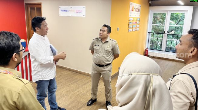 Pemimpin Redaksi Suara.com Suwarjono saat berdiskusi dengan Kepala Bidang Komunikasi Publik Dinas Kominfotik DKI Jakarta, Koharudin saat media visit di kantor Suara.com di kawasan Mega Kuningan, Jakarta Selatan, Senin (24/7/2023). [Suara.com/Dwi Bowo Raharjo]