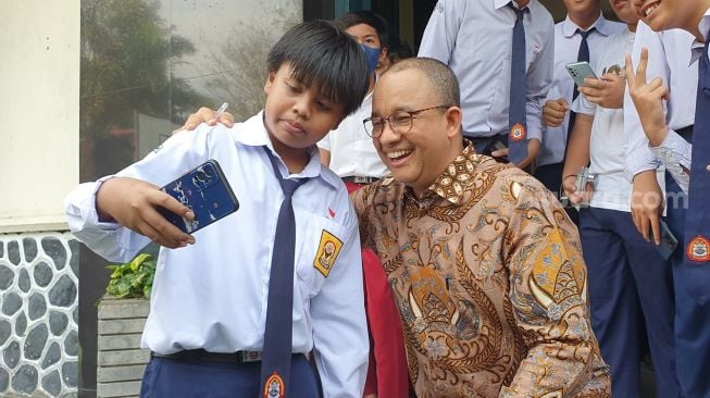 Anies Baswedan melayani permintaan foto bersama siswa-siswa di SMPN 5 Yogyakarta, Senin (24/7/2023). [Hiskia Andika Weadcaksana/Suarajogja.id] 