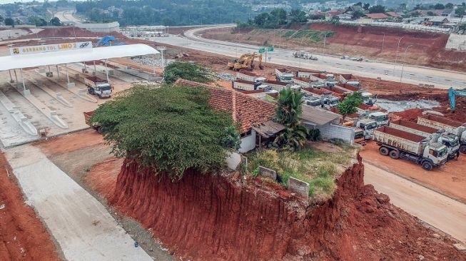 Foto udara rumah yang belum digusur pada proyek Jalan Tol Cijago seksi 3B yang menghubungkan wilayah Serpong,Cinere, dan Tol Jagorawi di Limo, Depok, Jawa Barat, Senin (24/7/2023). [ANTARA FOTO/Yulius Satria Wijaya].