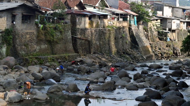 Warga berjalan di Sungai Ciliwung yang menyusut airnya di Kelurahan Babakan Pasar, Kota Bogor, Jawa Barat, Jumat (28/7/2023). [ANTARA FOTO/Arif Firmansyah].