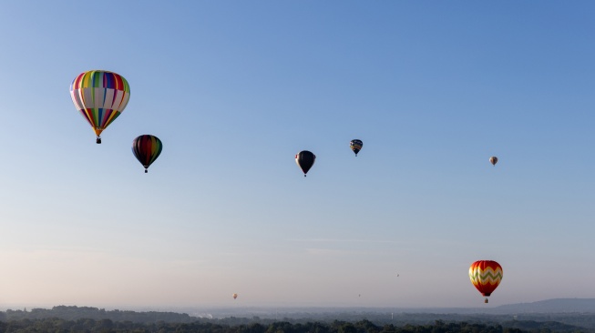 Balon udara terbang selama Festival Balon Tahunan New Jersey ke-40 di Bandara Solberg, Readington, New Jersey, Jumat (28/7/2023). [Julia Nikhinson / AFP]
