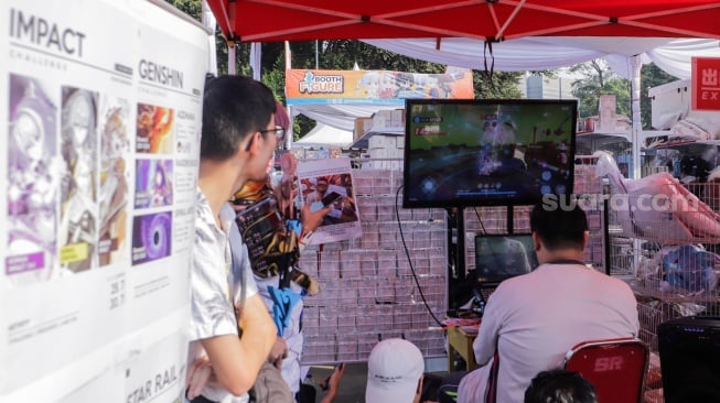 Pengunjung bermain game di acara Impacnation Japan Festival 2023 di Istora Senayan, Jakarta, Minggu (30/7/2023). [Suara.com/Alfian Winanto]